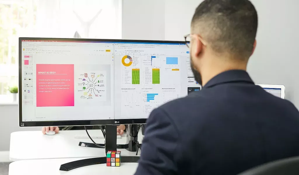 Bild på en SEO konsult som tittar på en stor skärm och arbetar med sökmotoroptimering.