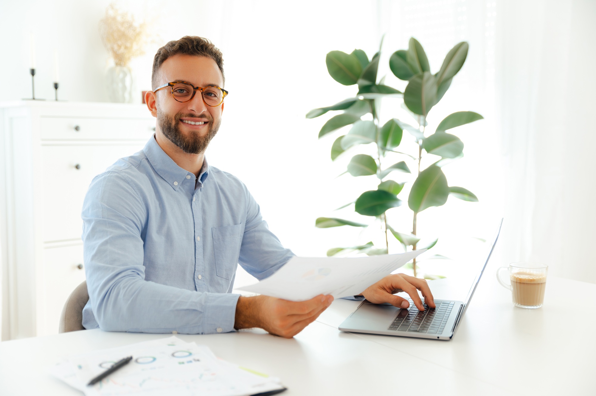 Confident caucasian or arabian man wearing blue shirt and glasses, company seo, holding a document