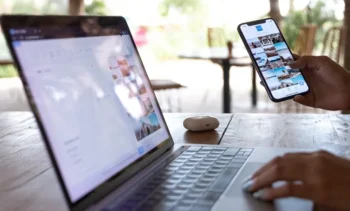 Bild på en öppen laptop och en person som håller i en telfon med ett instagram eller social media flöde uppe.