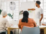 Man som beskriver målbild för hemsidor på en whiteboard.